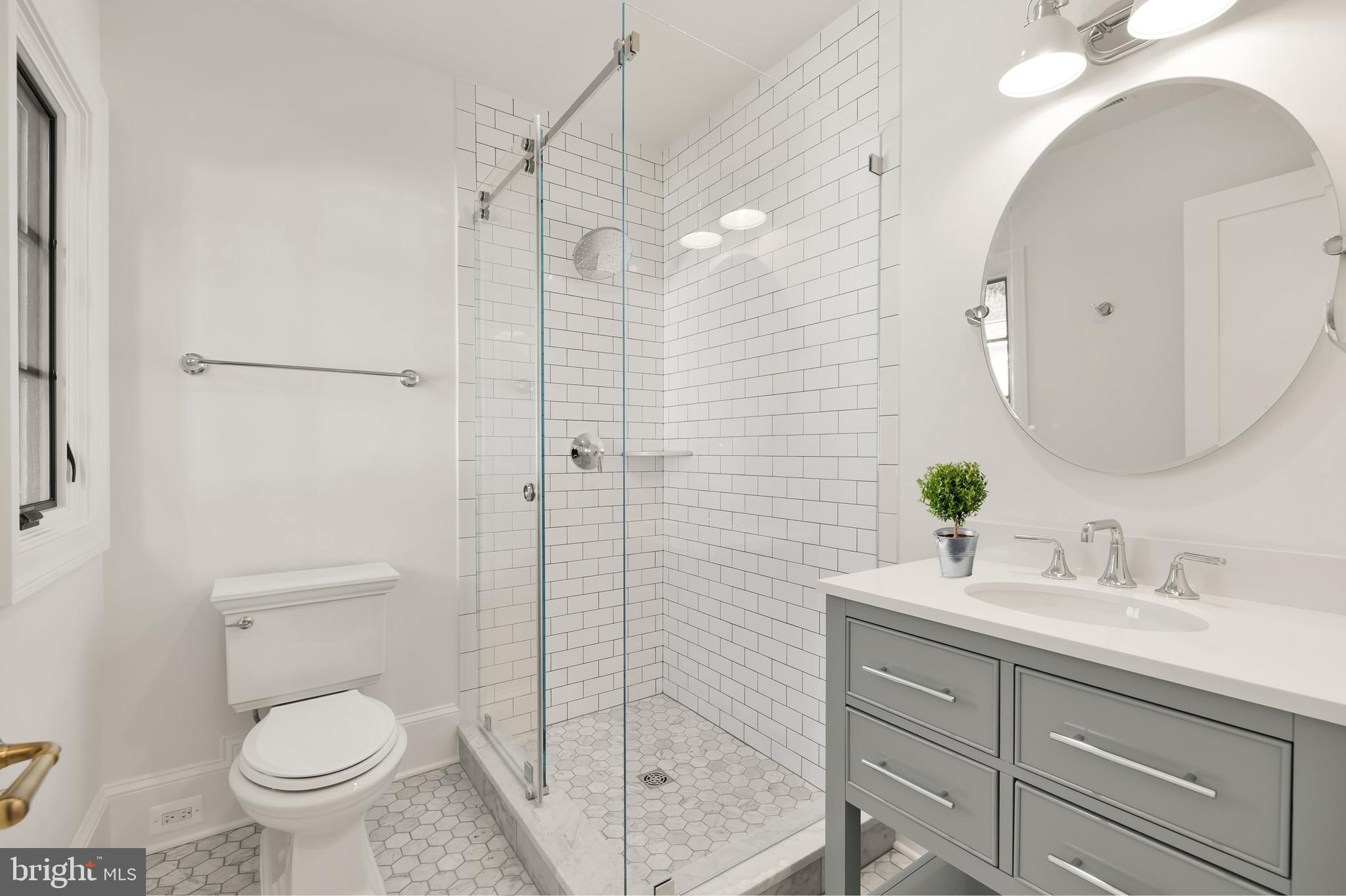 7611 Fairfax Road Bethesda, MD 20814 - Photo 31 of 44 a bathroom with a granite countertop sink a toilet and shower