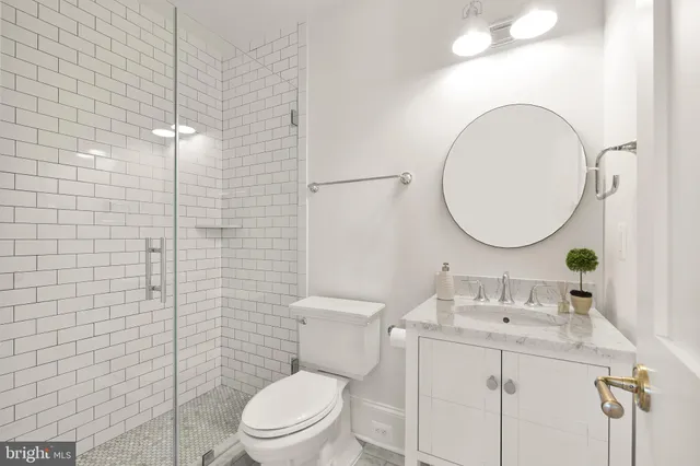 a bathroom with a toilet sink vanity and mirror