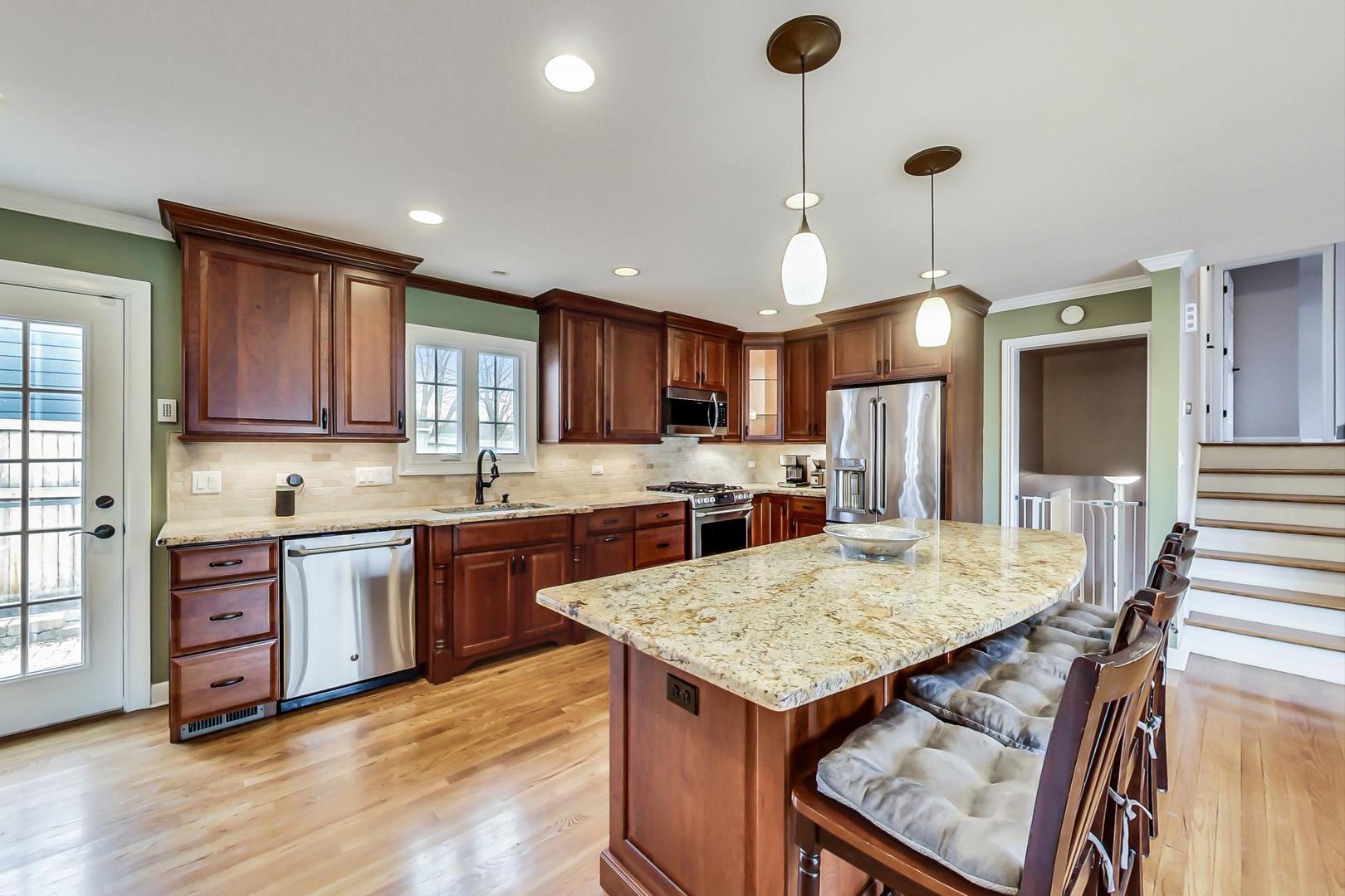 N369 Calvin Court Winfield, IL 60190 - Photo 9 of 41 a kitchen with granite countertop kitchen island stainless steel appliances and wooden cabinets