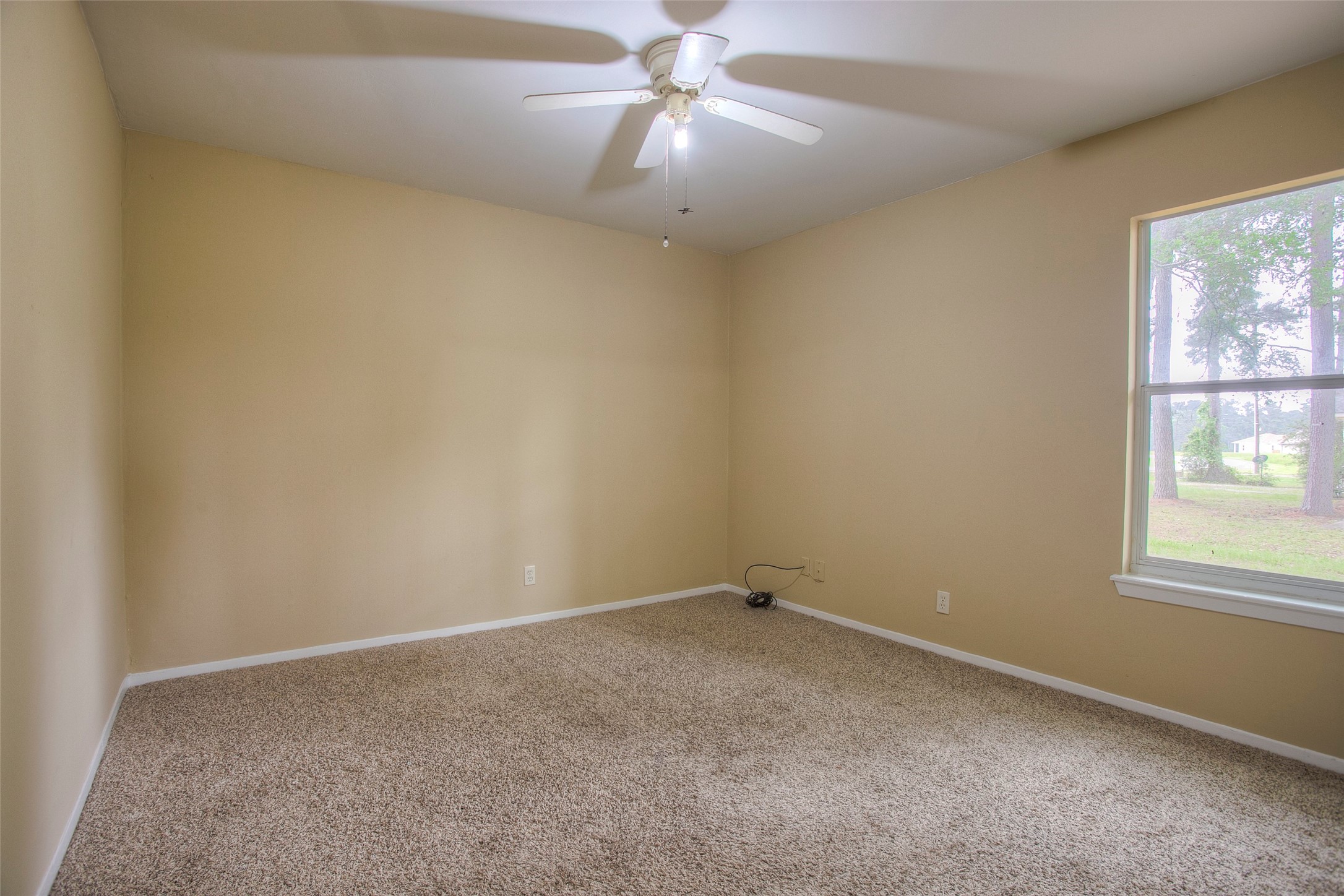 81 Westlake Road Trinity, TX 75862 - Photo 14 of 23 an empty room with a window and a fan