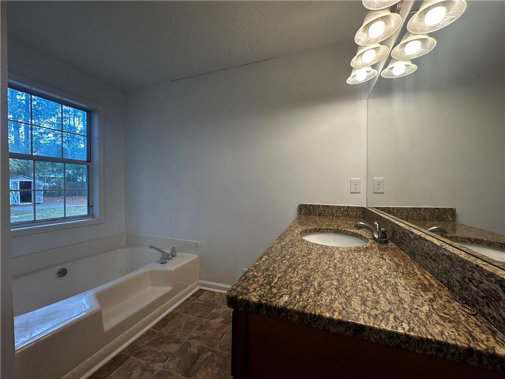 2536 Country Lake Circle Powder Springs, GA 30127 - Photo 15 of 25 a bathroom with a granite countertop sink a toilet and bathtub