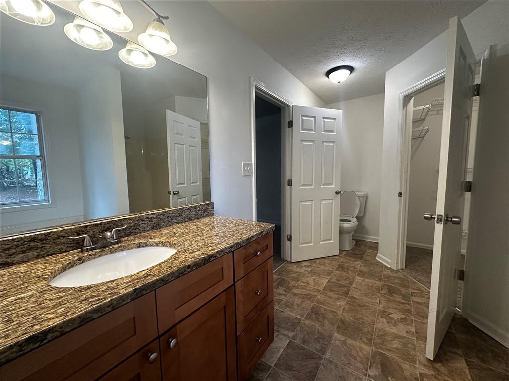 2536 Country Lake Circle Powder Springs, GA 30127 - Photo 17 of 25 a spacious bathroom with a granite countertop sink a mirror and a shower