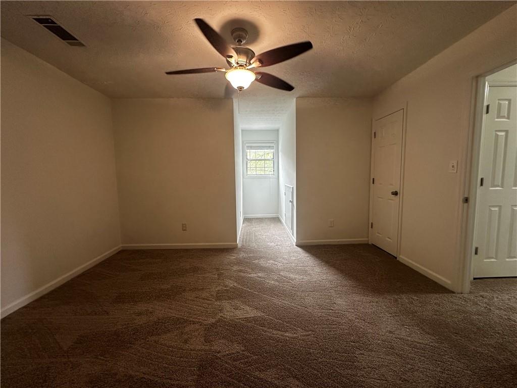 2536 Country Lake Circle Powder Springs, GA 30127 - Photo 23 of 25 an empty room with closet and a ceiling fan