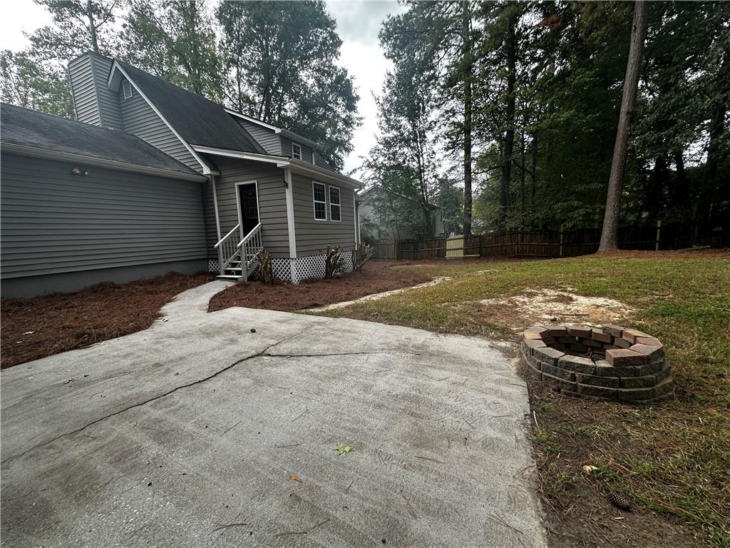 2536 Country Lake Circle Powder Springs, GA 30127 - Photo 24 of 25 a view of a backyard with table and chairs and a fire pit