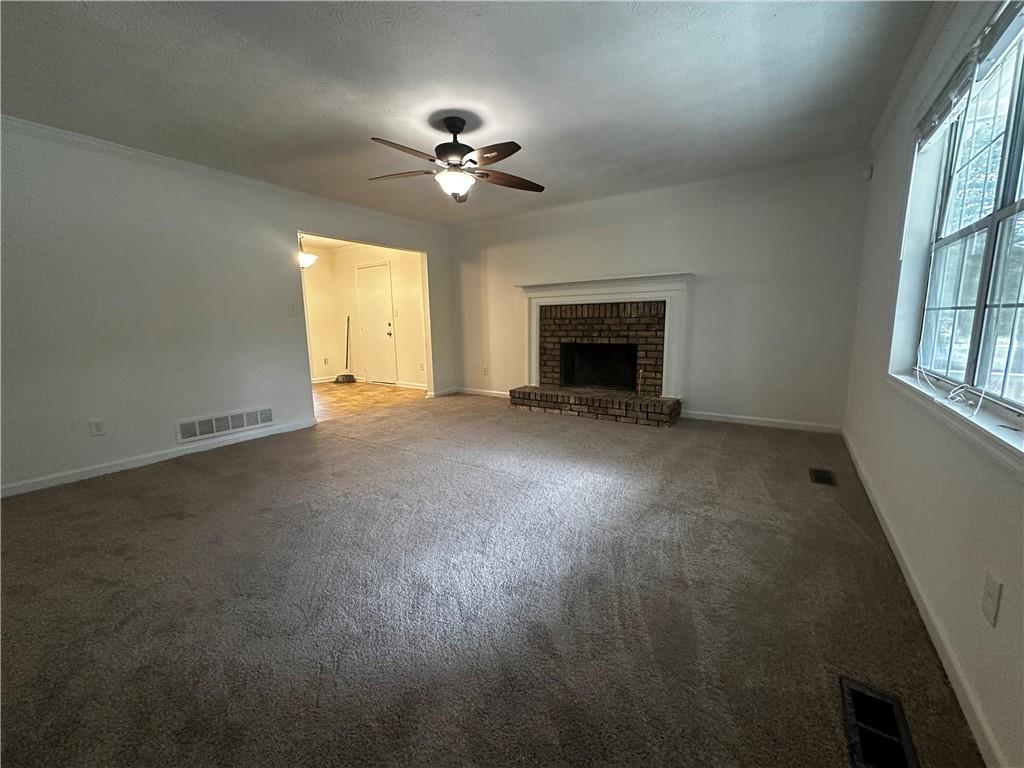 2536 Country Lake Circle Powder Springs, GA 30127 - Photo 6 of 25 a view of an empty room with chandelier fan and fire place