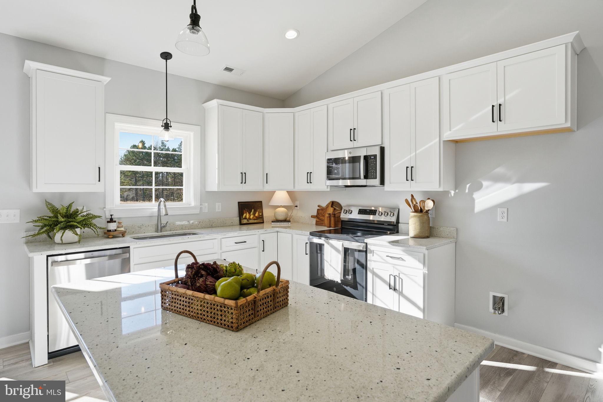 a living room with stainless steel appliances granite countertop a stove a sink a refrigerator a stove a dining table and chairs with wooden floor