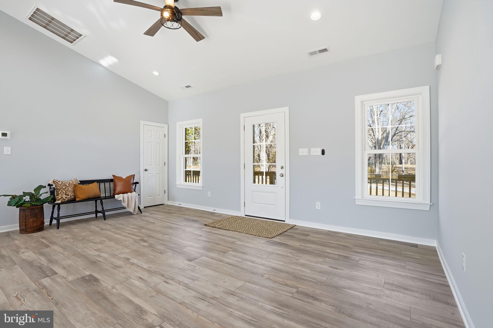 475 Fredericks Hall Road Bumpass, VA 23024 - Photo 14 of 44 an empty room with windows and ceiling fan