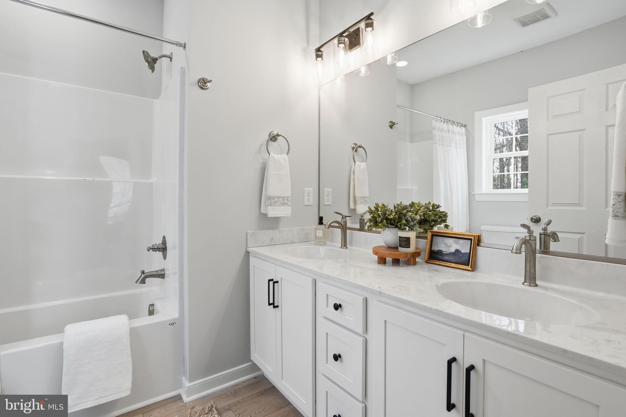 475 Fredericks Hall Road Bumpass, VA 23024 - Photo 23 of 44 a bathroom with a tub sink and mirror