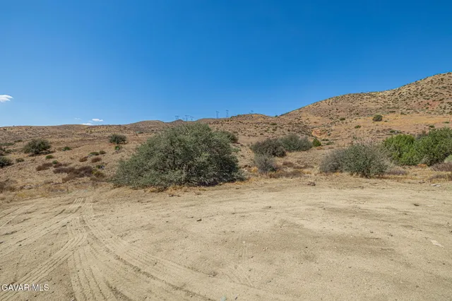 a view of a dry space with mountains in the background