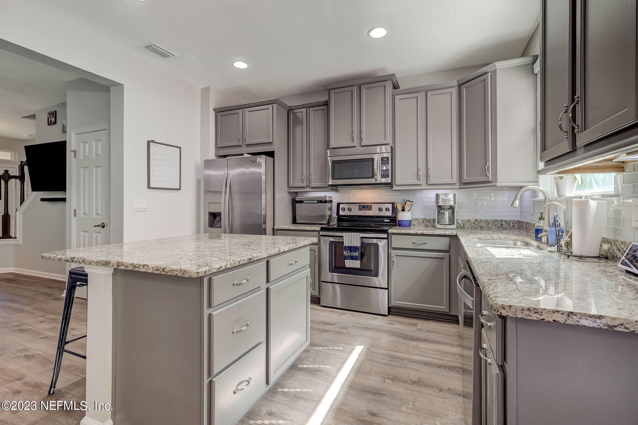 a kitchen with kitchen island granite countertop stainless steel appliances and sink
