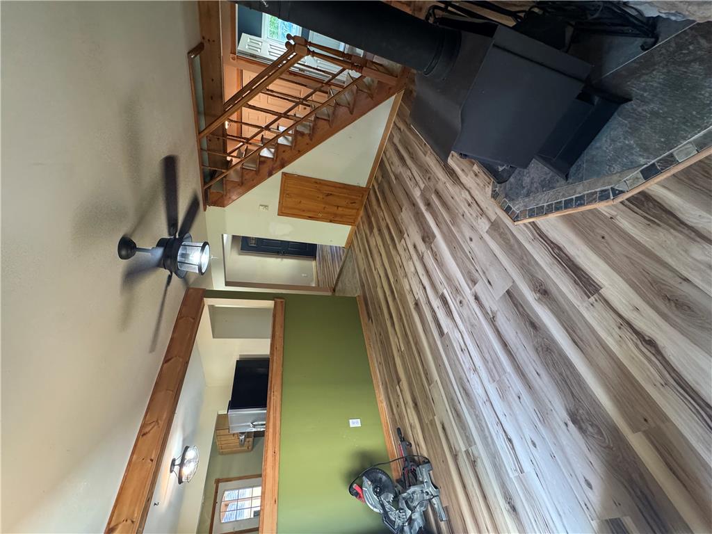 134 Bear Road Kunkletown, PA 18058 - Photo 14 of 42 Gleaming wood floors anchor this open living area featuring a rustic wood stove and staircase.
