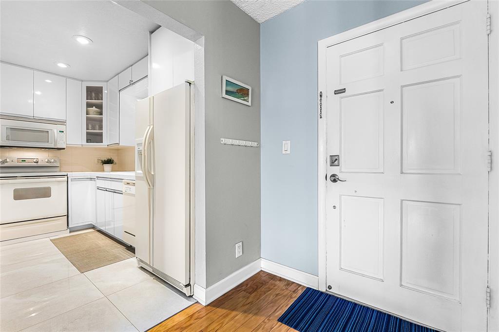 3216 Southeast 8th Street, Unit 303 Pompano Beach, FL 33062 - Photo 13 of 54 a kitchen with white cabinets and white appliances