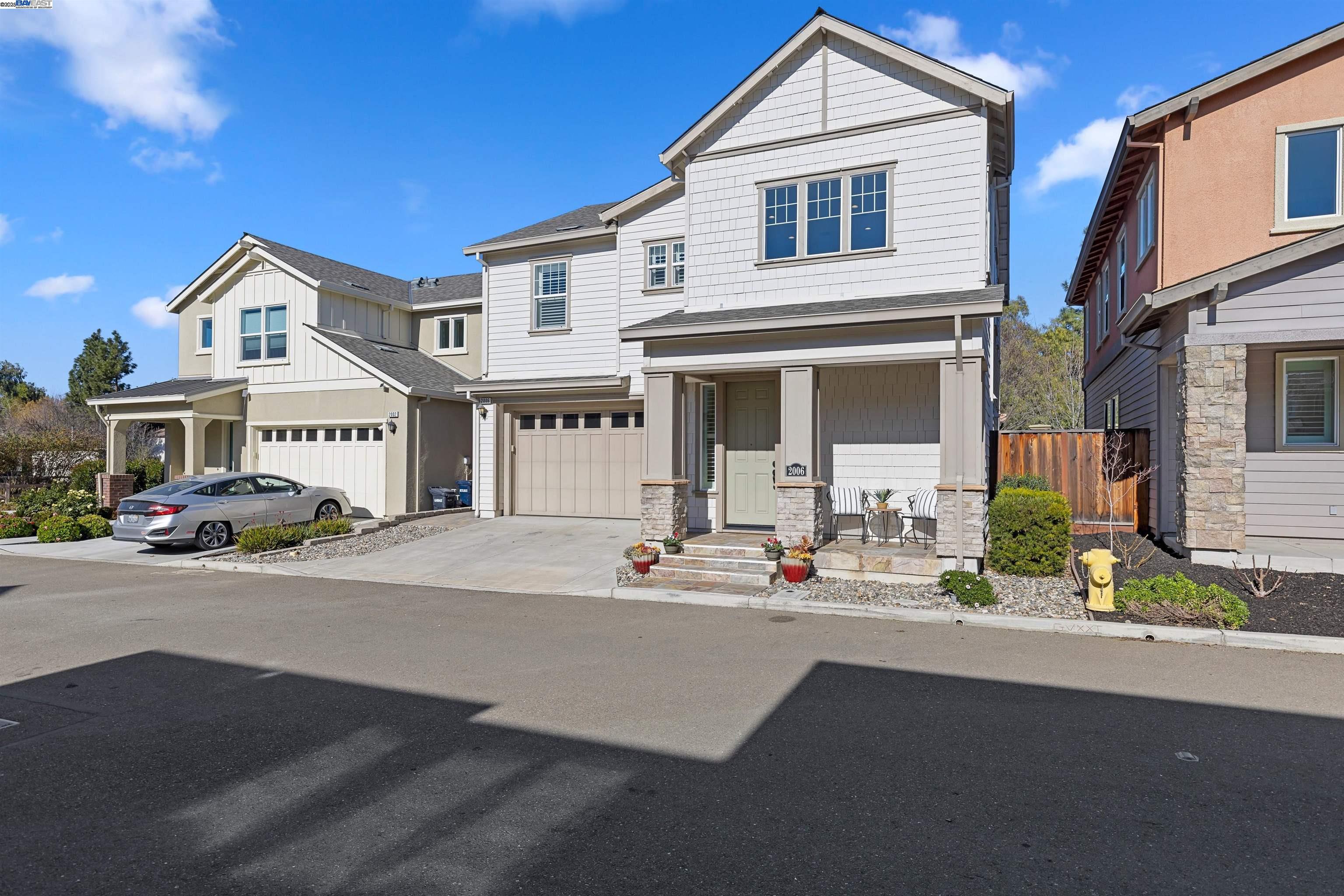 a view of a white house with large windows and a car parked in front of it