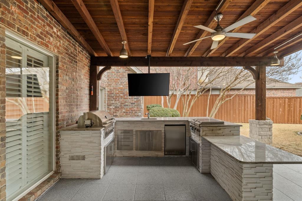 4512 Banyon Lane Dallas, TX 75287 - Photo 37 of 40 4512 Banyan Ln-Built tin kitchen with sink, granite counters, and large gas grill by Fang Underhill.