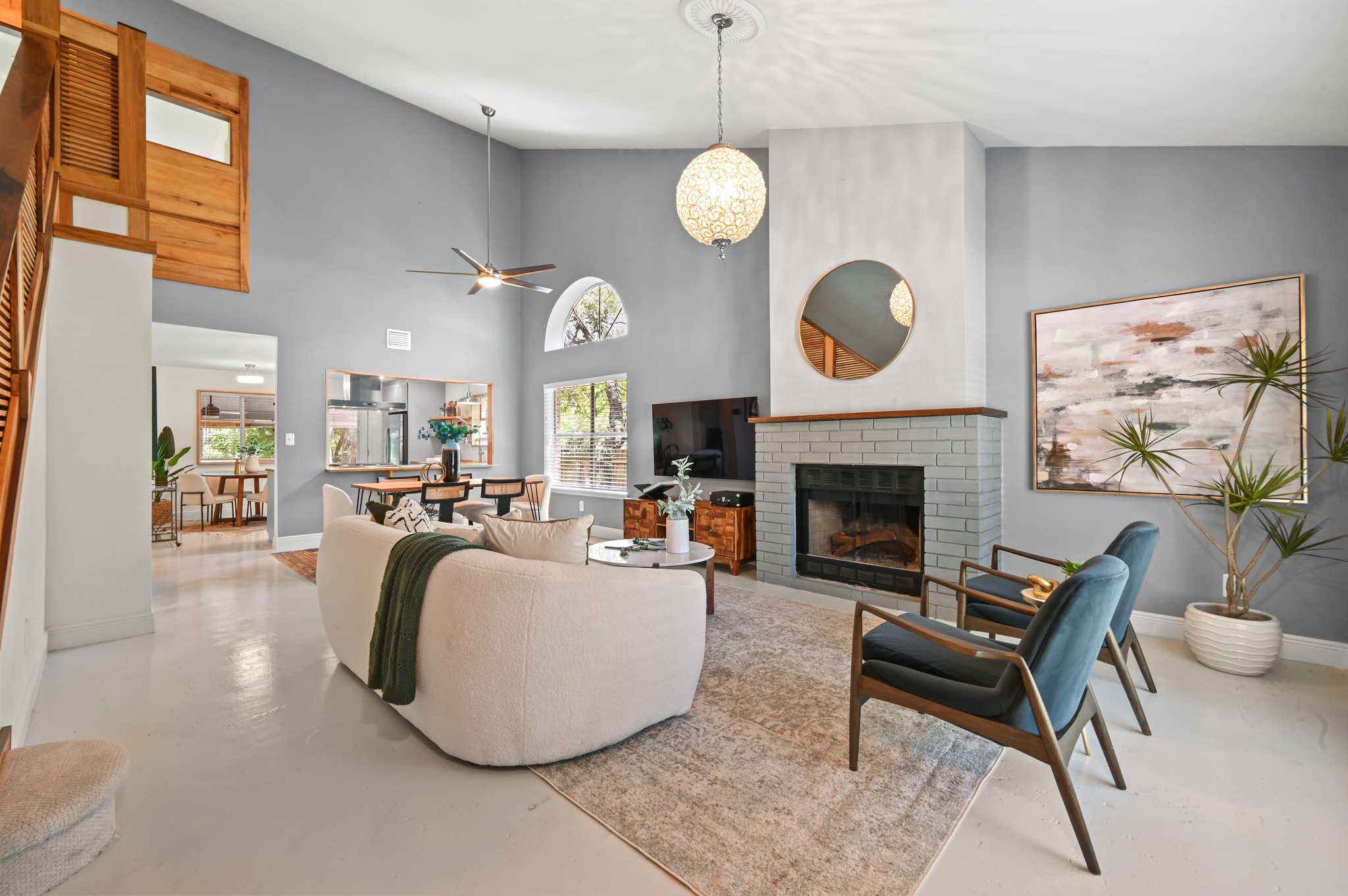 708 Shade Tree Drive Austin, TX 78748 - Photo 12 of 32 The living room centers around a striking fireplace framed in a brick hearth with a designer chandelier above and a large picture window overlooking the front yard that infuses the space in warm natural light.