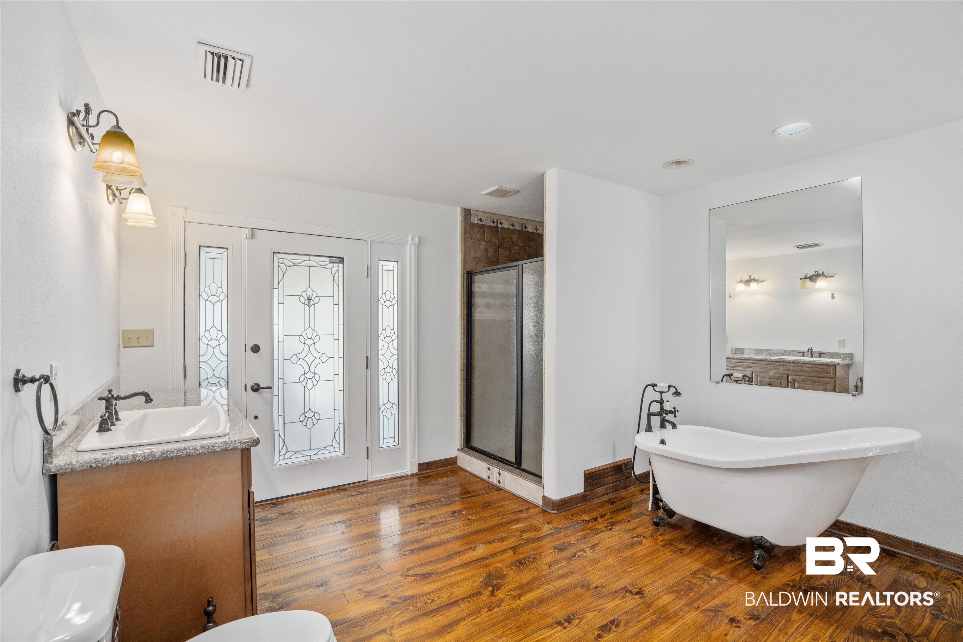 51699 Highway 31 Perdido, AL 36562 - Photo 19 of 30 Bathroom with baseboards, visible vents, a soaking tub, wood finished floors, and vanity