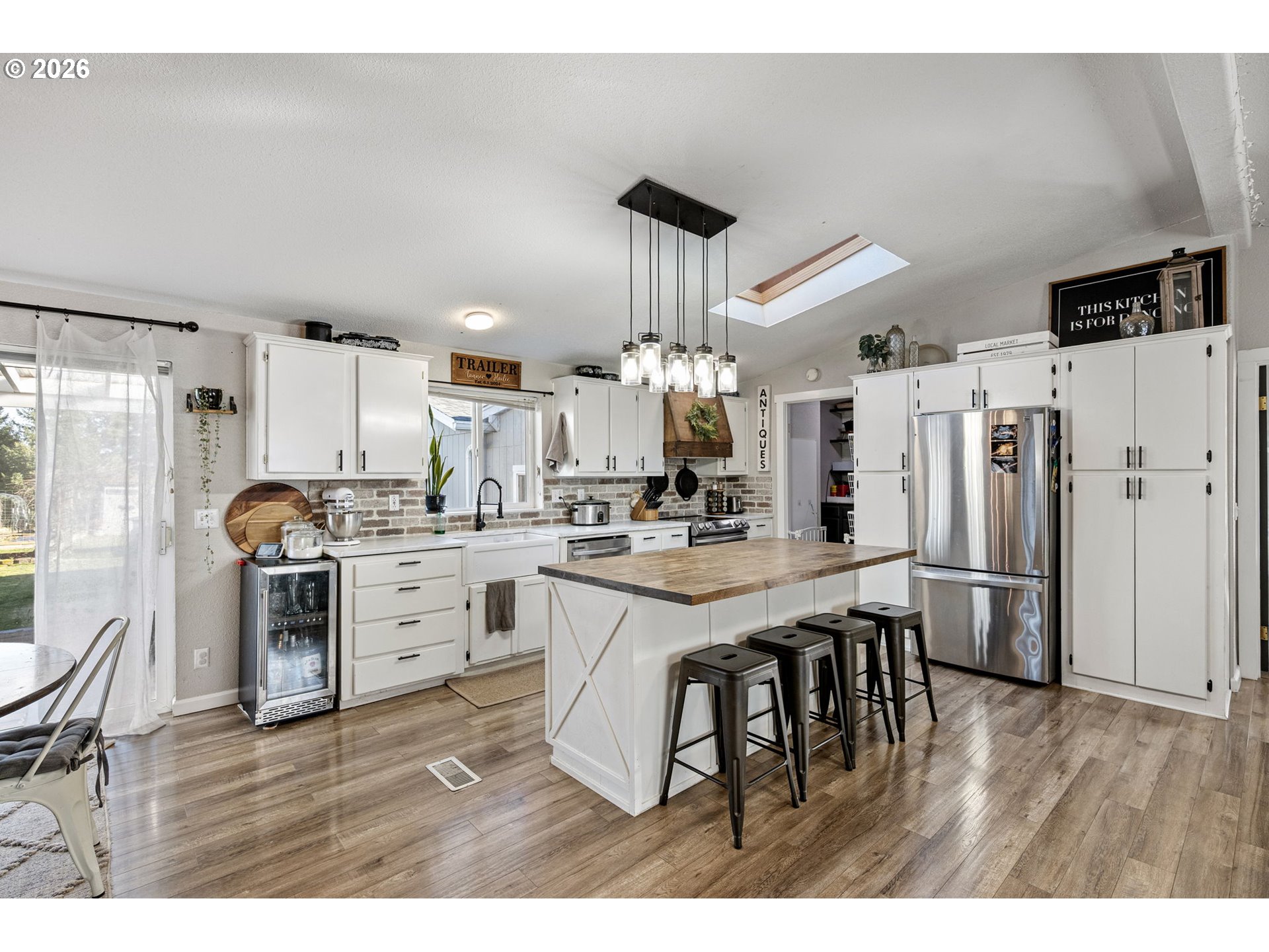 83149 Mickelson Road Creswell, OR 97426 - Photo 3 of 34 a kitchen with kitchen island a refrigerator stove and white cabinets