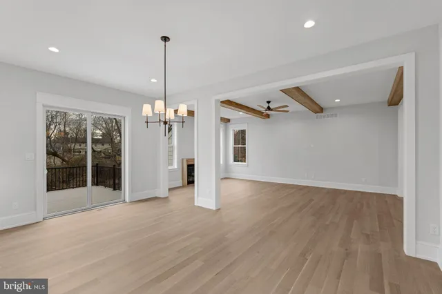 a view of a room with wooden floor chandelier and windows