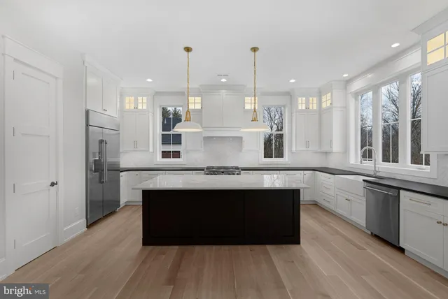 a view of kitchen with stainless steel appliances granite countertop a stove a sink and a wooden floors