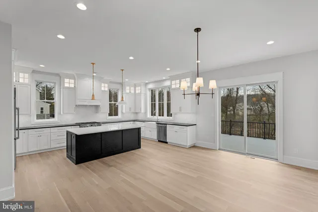 a large kitchen with kitchen island a sink stainless steel appliances and cabinets