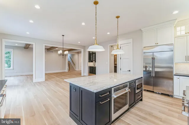 a kitchen with stainless steel appliances granite countertop a kitchen island a refrigerator and a sink