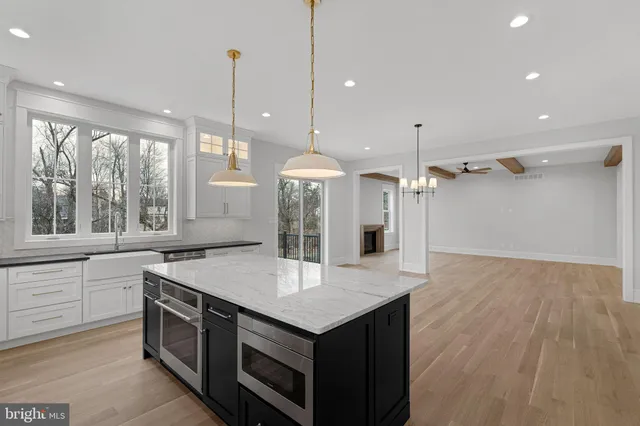 a kitchen with a stove a sink a counter space and wooden floor
