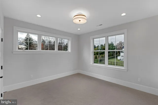 an empty room with mirror and a bathroom