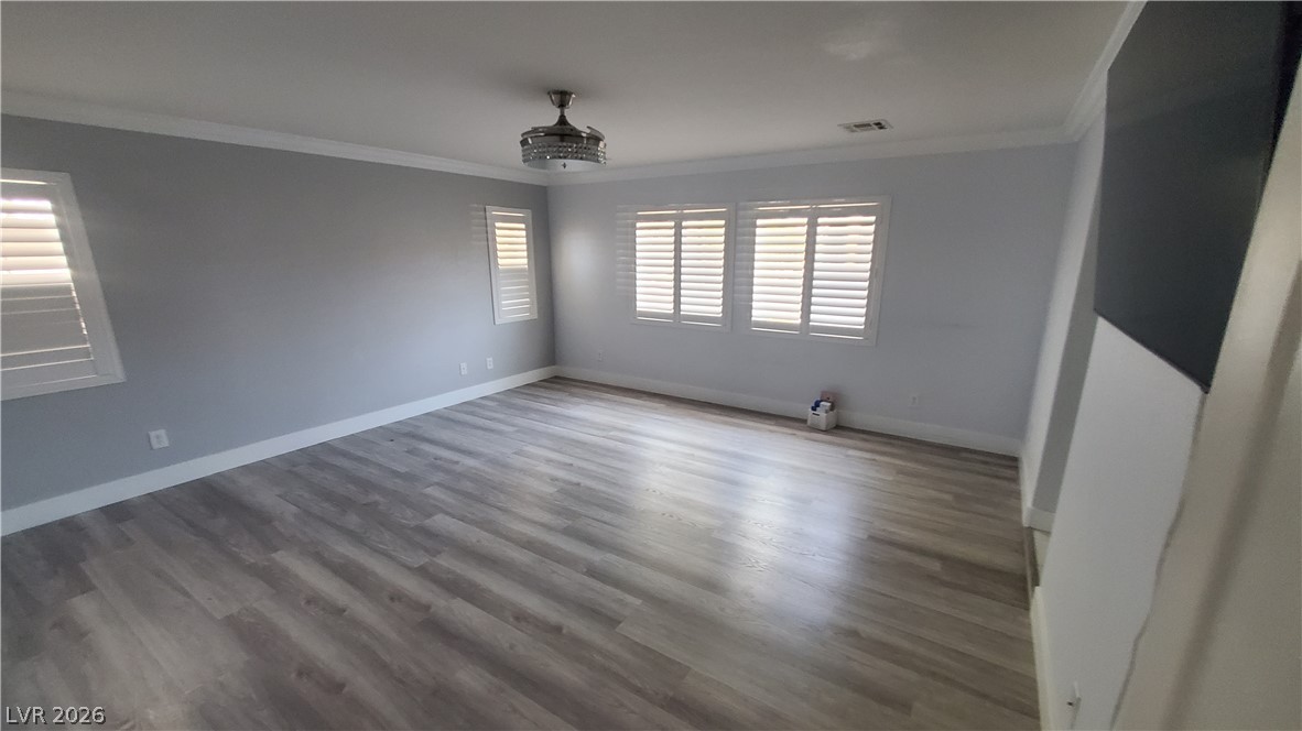 7903 Dell Ridge Avenue Las Vegas, NV 89179 - Photo 9 of 20 A naturally illuminated room boasts hardwood flooring and pristine crown molding.