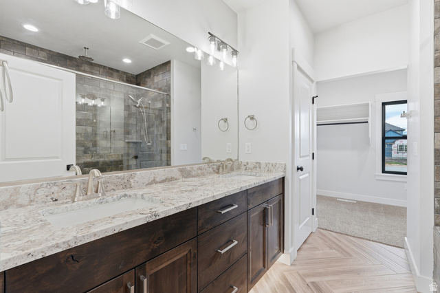 2970 North Mahogany Vly Road Logan, UT 84341 - Photo 13 of 39 Bathroom with double vanity, parquet floors, a shower stall, and a spacious closet