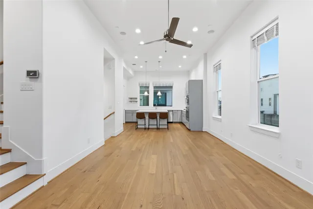 a view of a livingroom with a large window and wooden floor