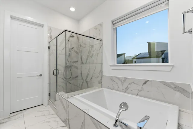 a bathroom with a tub sink shower and mirror