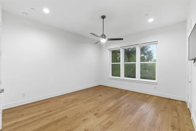an empty room with wooden floor and window