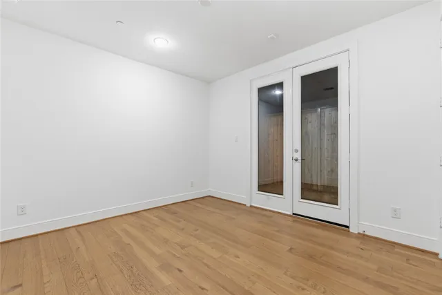 an empty room with wooden floor and entrance