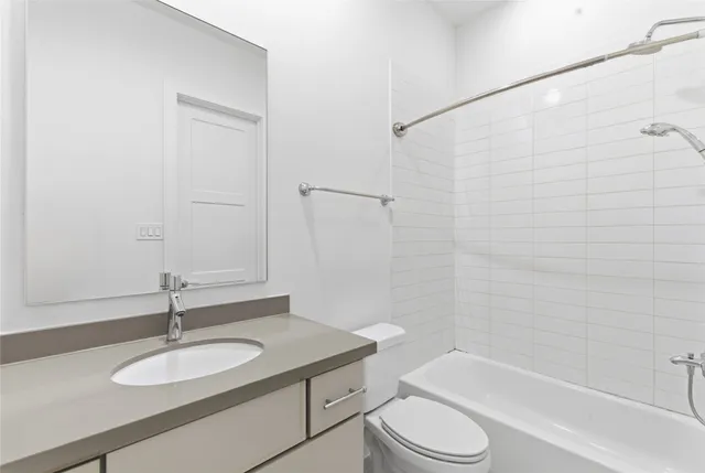 a bathroom with a granite countertop sink toilet a mirror and shower