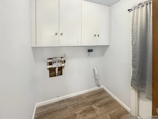 a view of a refrigerator in kitchen with white cabinets