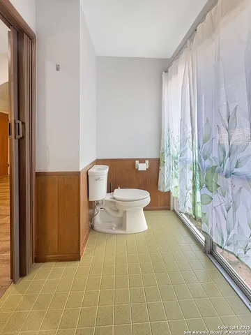 a bathroom with a toilet and a shower