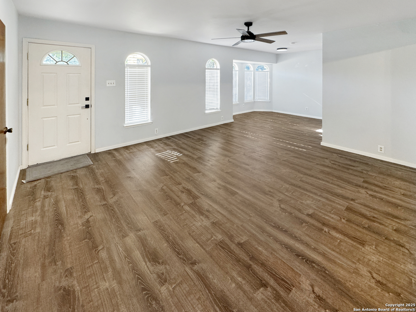 10806 Mount Tipton San Antonio, TX 78213 - Photo 4 of 22 an empty room with wooden floor ceiling fan and windows