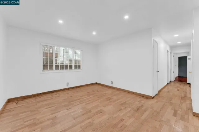 a view of empty room with wooden floor