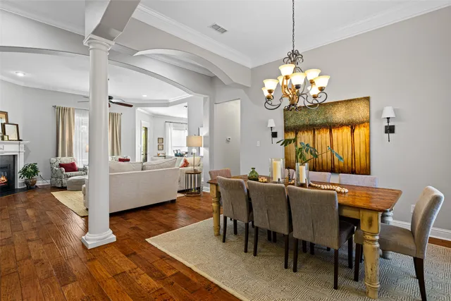 a view of a dining room with furniture a chandelier and wooden floor
