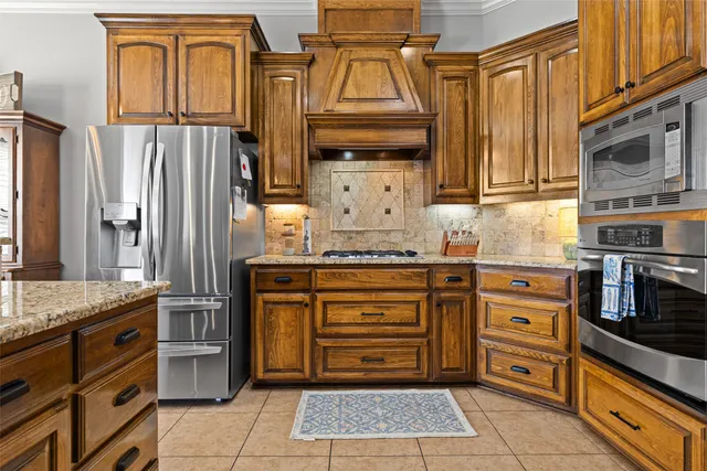 a kitchen with stainless steel appliances granite countertop a refrigerator and a stove