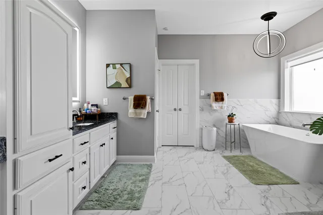 a bathroom with a granite countertop sink a toilet a mirror and vanity