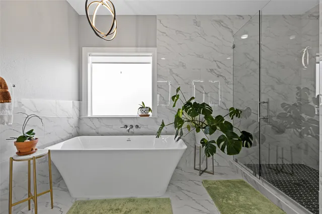 a white bath tub sitting in a bathroom next to a window