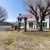 a white house that has a tree in front of it