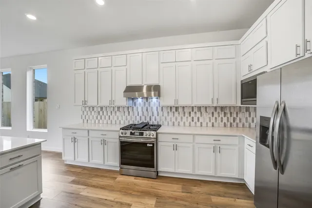 a kitchen with stainless steel appliances granite countertop a stove a sink and a refrigerator