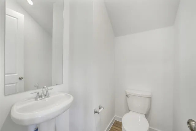 a bathroom with a sink a toilet and mirror