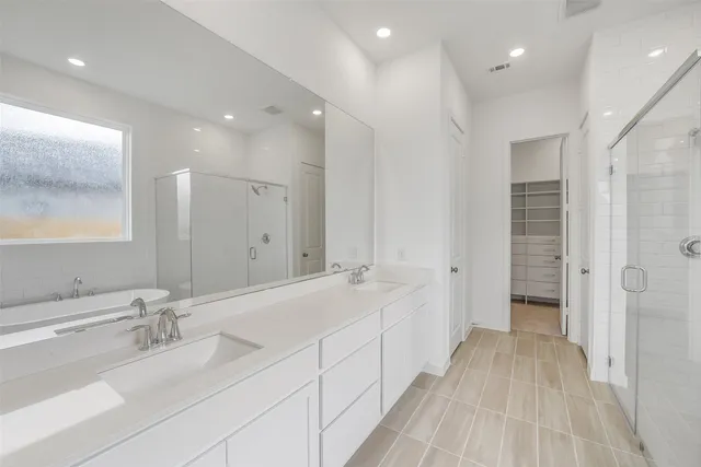a spacious bathroom with a double vanity sink and a mirror