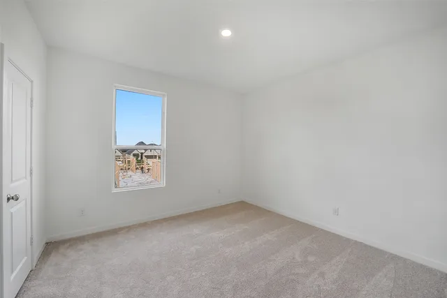 an empty room with a white wall and a window