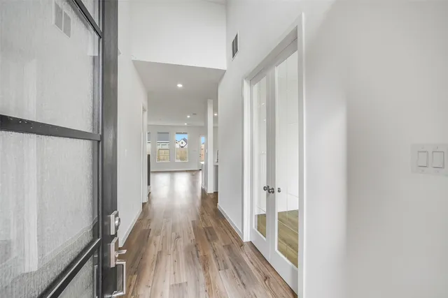 a view of a hallway with wooden floor and staircase