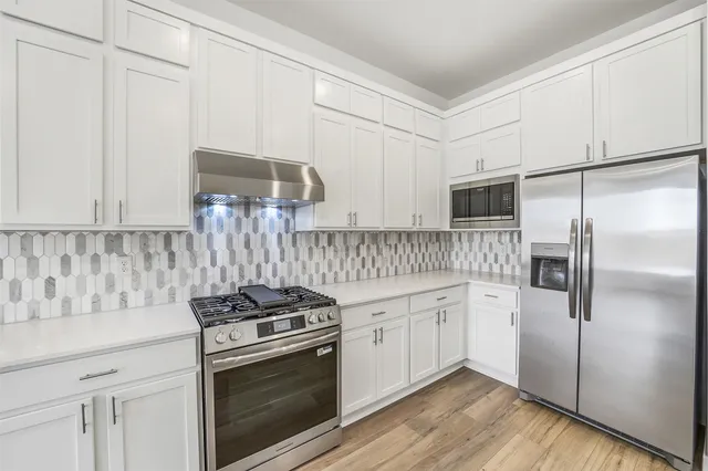 a kitchen with white cabinets and white appliances