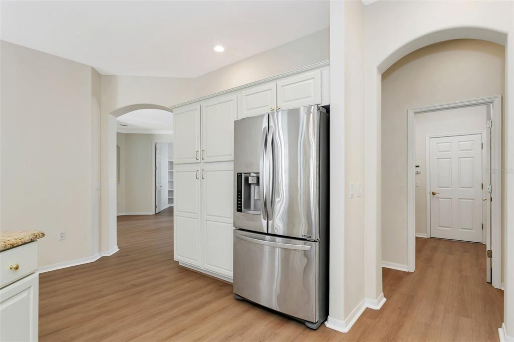 11209 Pine Lilly Place Lakewood Ranch, FL 34202 - Photo 9 of 26 a kitchen with stainless steel appliances a refrigerator and wooden floor